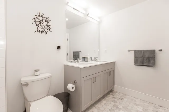 a bathroom with a toilet a sink and mirror