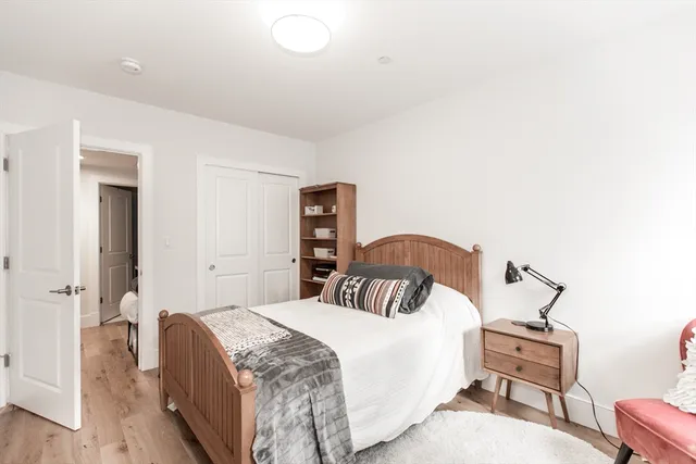 a bedroom with a bed and wooden floor