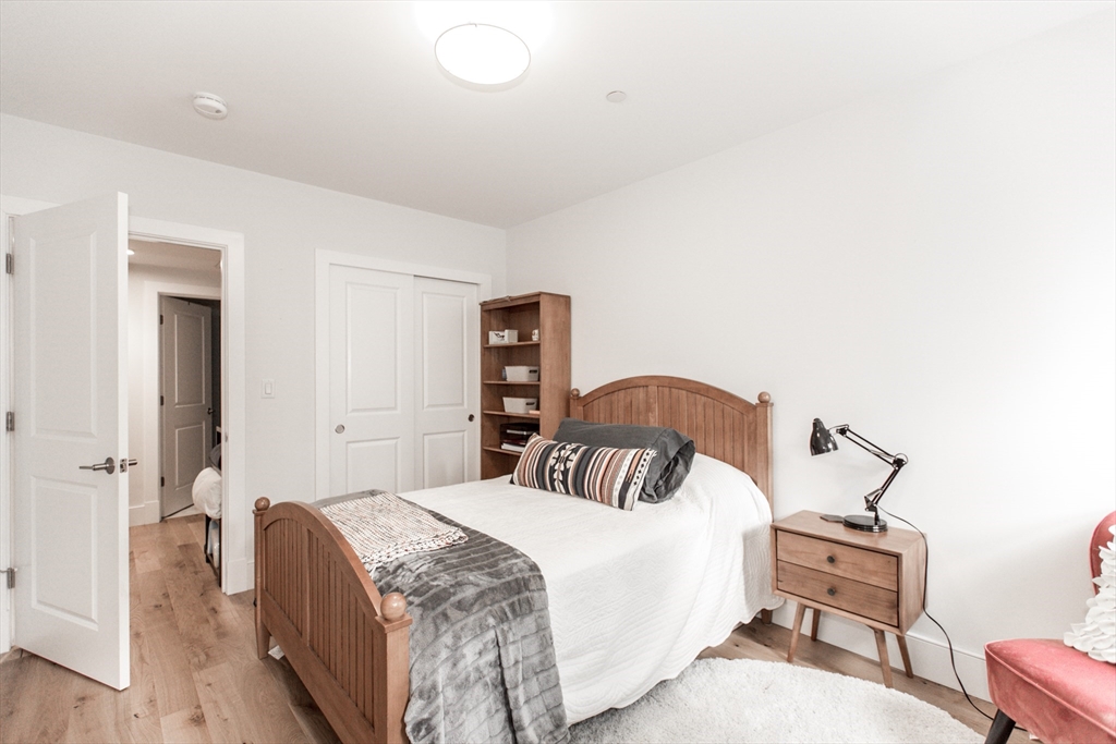 30 Polk Street, Unit 103 Boston, MA 02129 - Photo 13 of 20 a bedroom with a bed and wooden floor