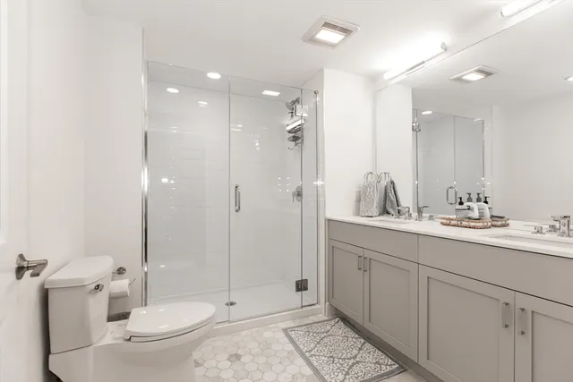 a bathroom with a double vanity sink toilet and shower