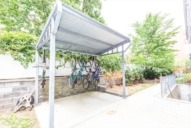 a view of a patio with a table and chairs under an umbrella with a large tree