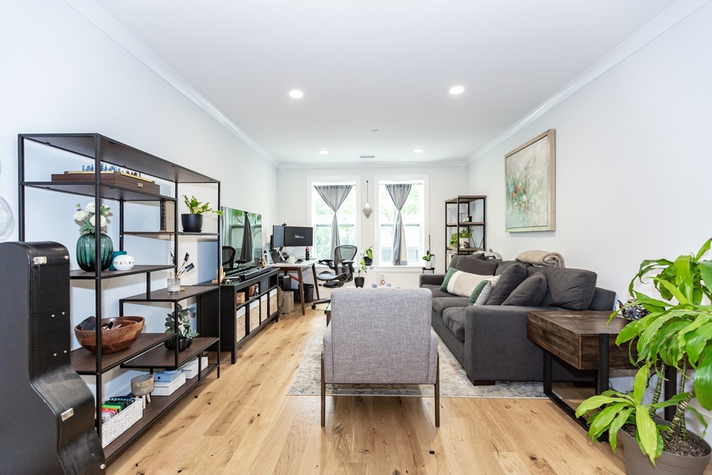 30 Polk Street, Unit 103 Boston, MA 02129 - Photo 6 of 20 a living room with furniture and a wooden floor