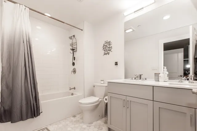 a bathroom with a bathtub shower sink vanity and toilet