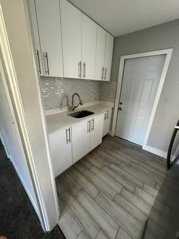 a kitchen with a sink a refrigerator and cabinets