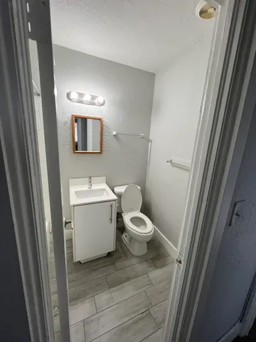 a bathroom with a toilet sink and mirror