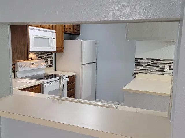 a kitchen with a refrigerator and a stove