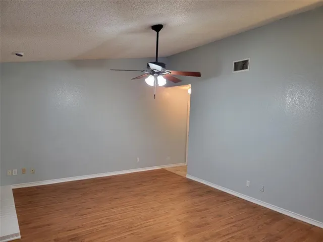 a view of a room with wooden floor fan and window