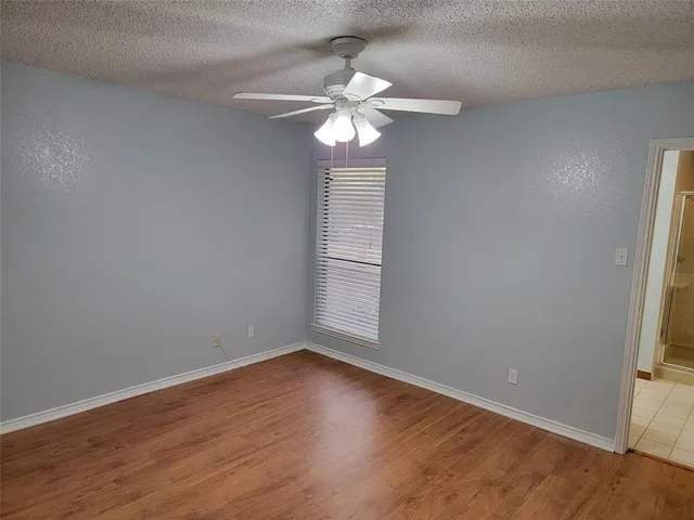 a view of wooden floor and chandelier fan in a room