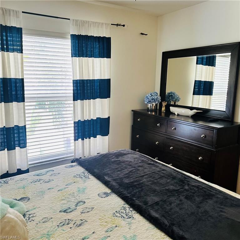 21300 Lancaster Run, Unit 926 Estero, FL 33928 - Photo 16 of 24 a bedroom with a bed and a mirror
