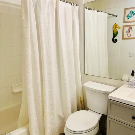 a white toilet sitting next to a shower curtain