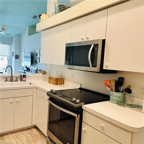 a kitchen with stainless steel appliances a sink stove and microwave