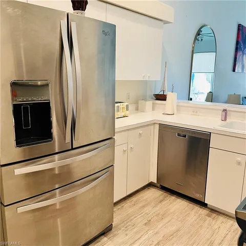 a kitchen with a refrigerator sink and cabinets