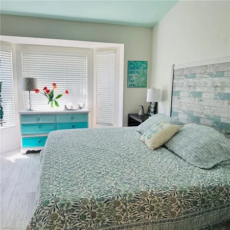 a bedroom with a bed table and window