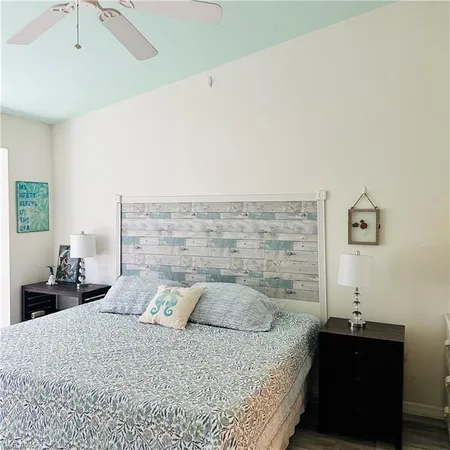 a bedroom with a bed and a lamp on the dresser