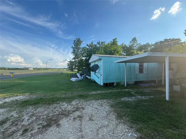 a backyard of a house with plants and wooden fence