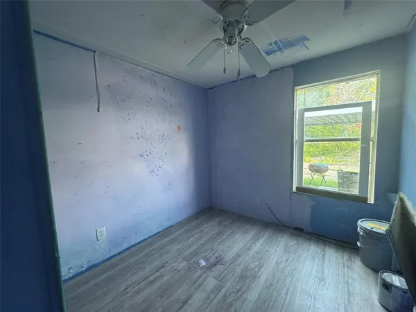 an empty room with a window and wooden floor