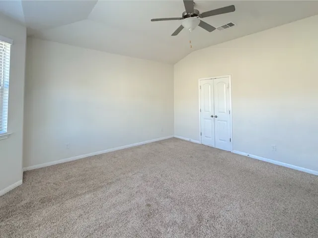 an empty room with a window and a fan