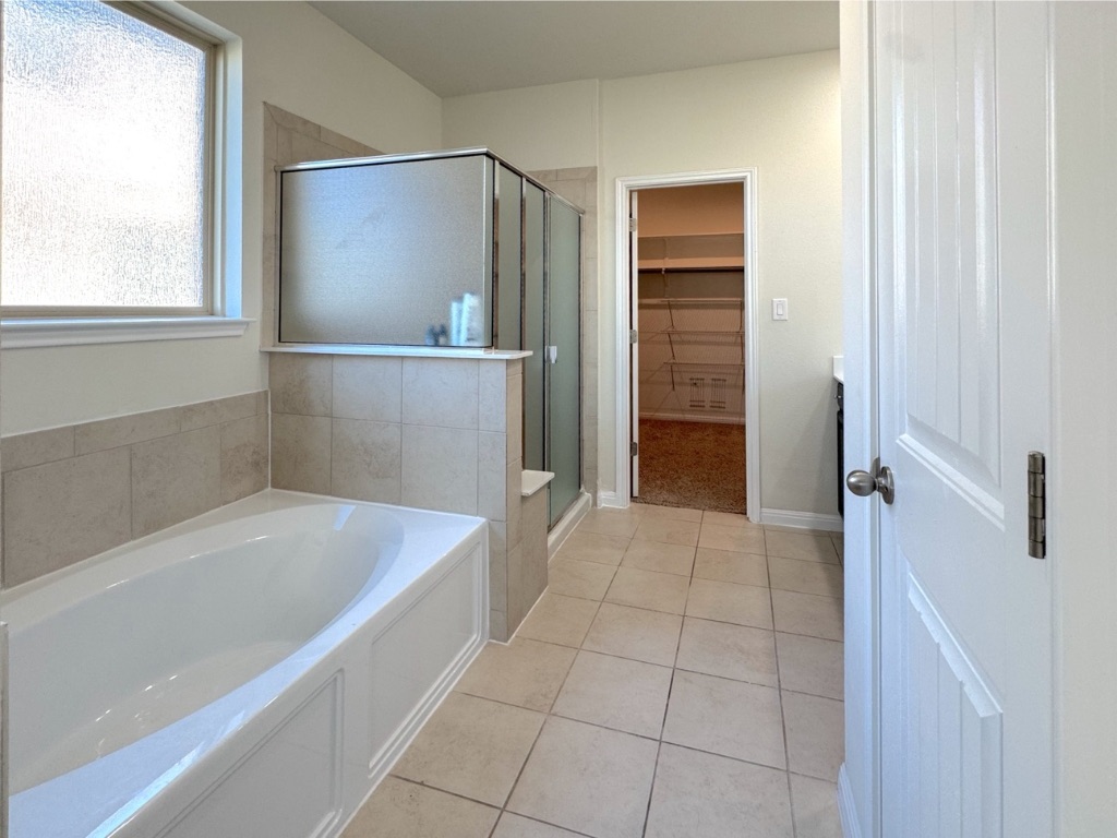 2056 Hat Bender Loop Round Rock, TX 78664 - Photo 14 of 27 a bathroom with a bathtub and a shower