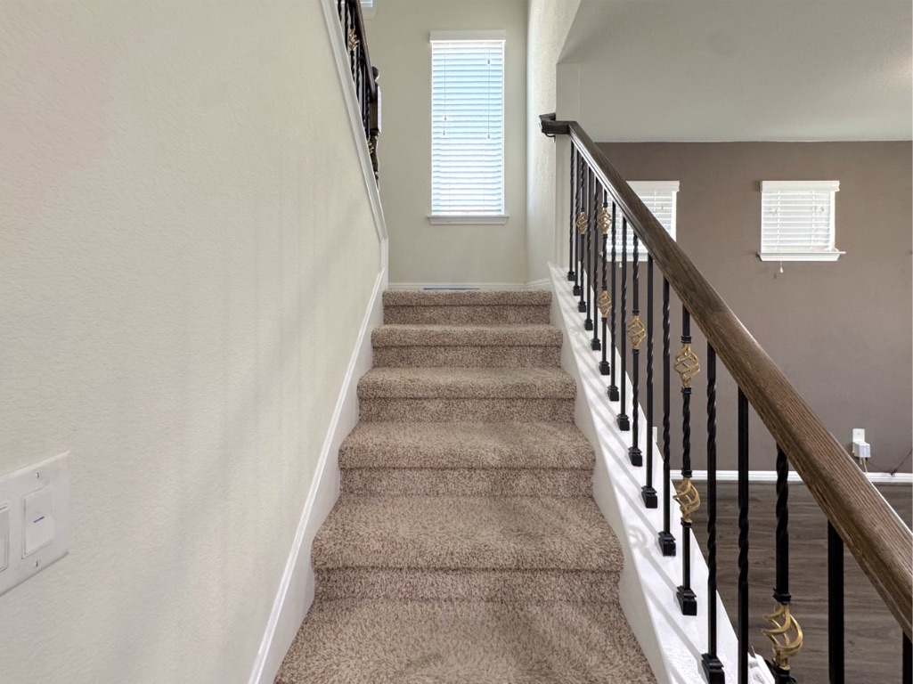 2056 Hat Bender Loop Round Rock, TX 78664 - Photo 17 of 27 a view of staircase with lots of frames on wall and wooden floor
