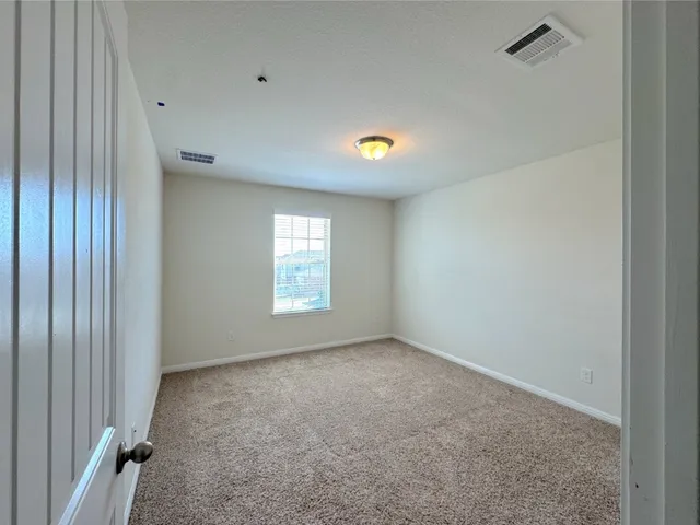an empty room with closet and windows