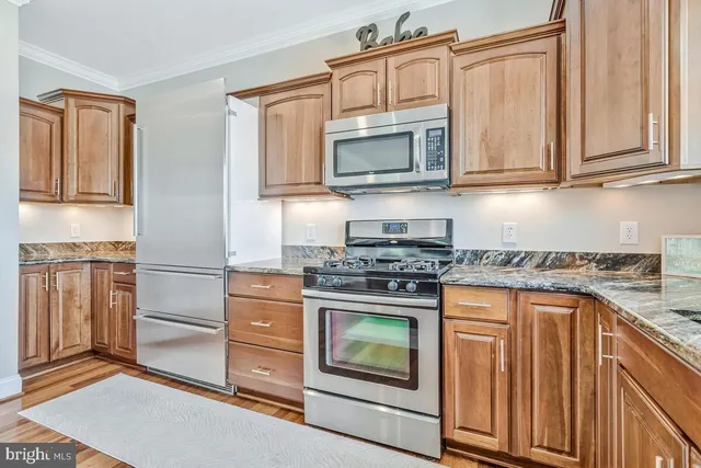a kitchen with stainless steel appliances granite countertop a stove microwave and cabinets