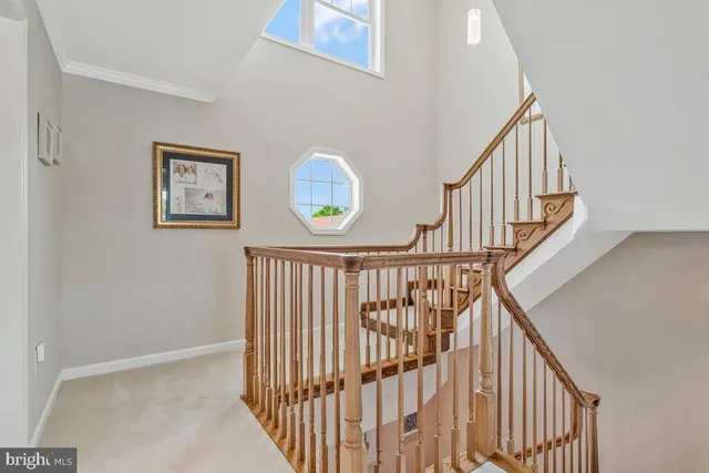 a view of staircase with railing and white walls