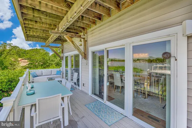 a view of a patio with table and chairs with wooden floor and fence