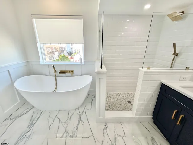 a spacious bathroom with a double vanity sink mirror and bathtub
