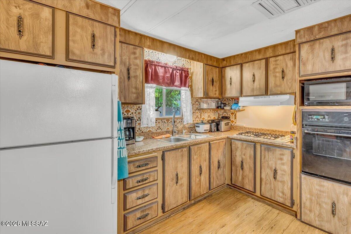 5379 West Rafter Cir Street Tucson, AZ 85713 - Photo 3 of 38 a kitchen with stainless steel appliances a refrigerator sink and cabinets