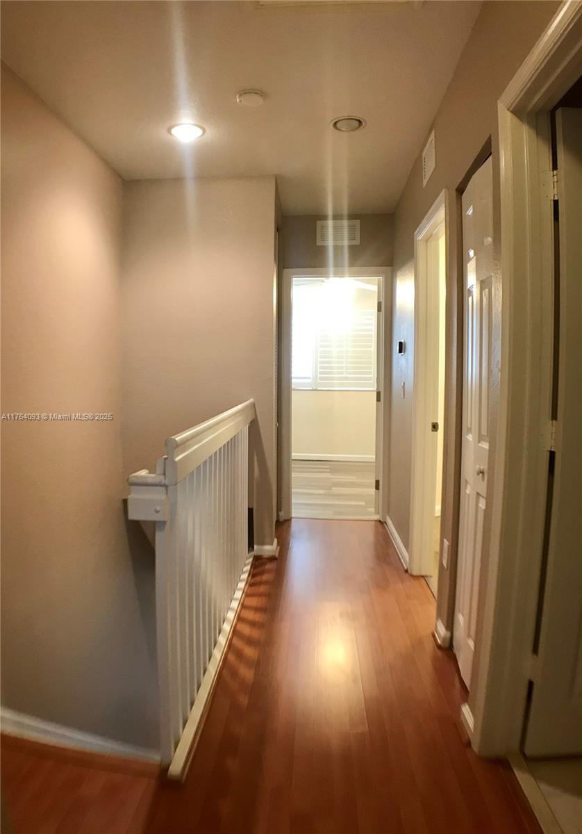 8253 Southwest 29th Street, Unit 104 Miramar, FL 33025 - Photo 8 of 17 a view of a hallway with wooden floor and a bathroom