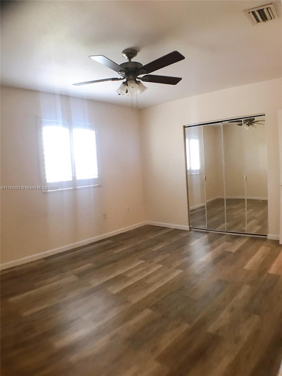 8253 Southwest 29th Street, Unit 104 Miramar, FL 33025 - Photo 10 of 17 an empty room with wooden floor fan and windows
