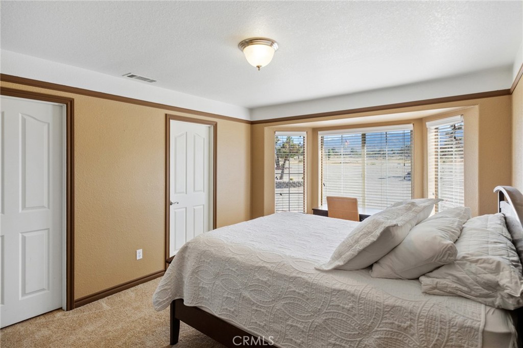 11025 El Esteban Road Phelan, CA 92371 - Photo 31 of 54 a bedroom with a large bed and a large window