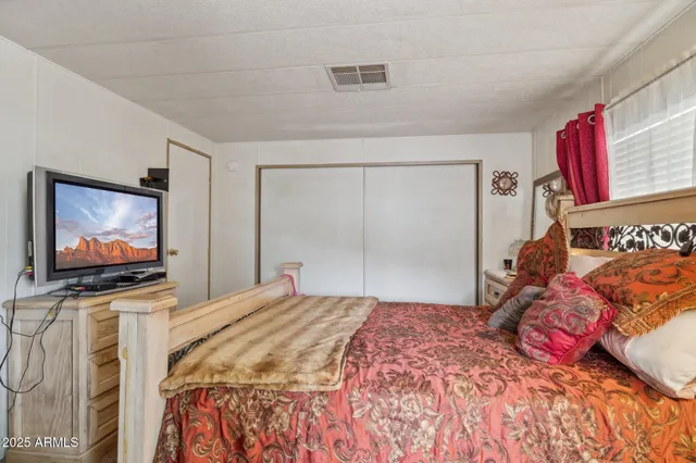 a bedroom with a bed and a flat screen tv