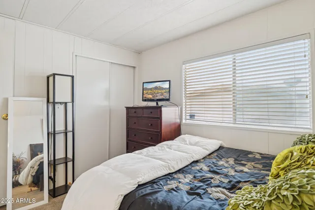 a bedroom with a bed dresser and a window