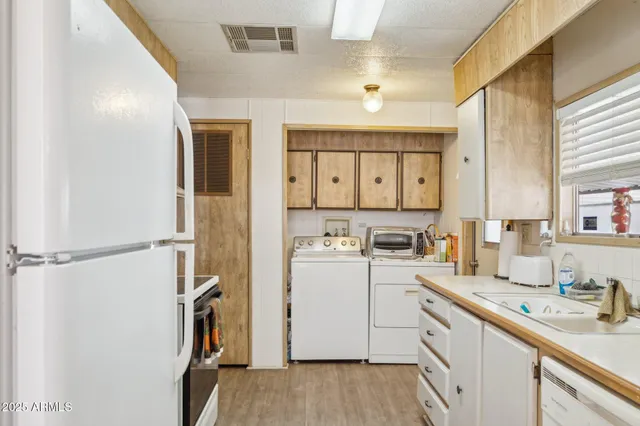 a kitchen with a sink a refrigerator a stove and cabinets