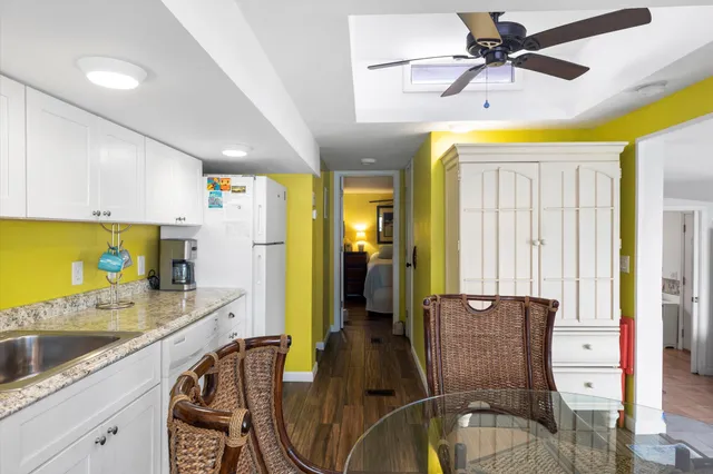 a kitchen with stainless steel appliances kitchen island granite countertop a table chairs in it and a sink