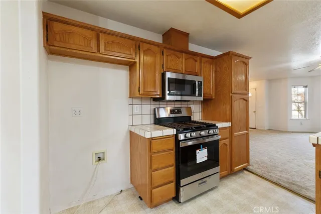 an empty room with windows and chandelier fan