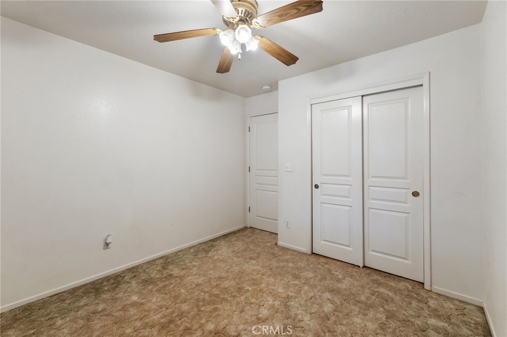 952 Upp Court Hanford, CA 93230 - Photo 15 of 35 an empty room with closet and a chandelier fan