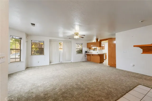 a view of an empty room with a fireplace and window
