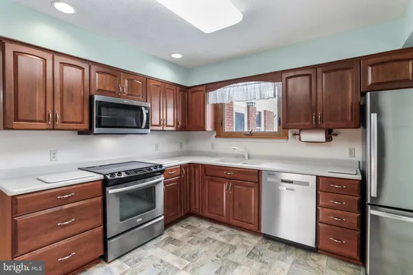 a kitchen with stainless steel appliances granite countertop a stove microwave and refrigerator