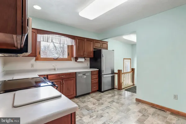 a kitchen with stainless steel appliances granite countertop a stove refrigerator sink and microwave