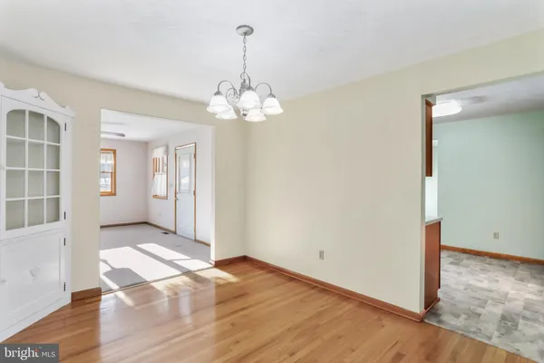 a view of a livingroom with a chandelier wooden floor and front door
