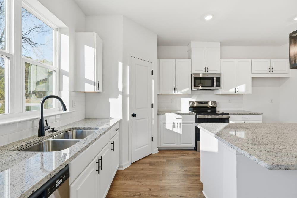 5708 Schelton Place Southeast Mableton, GA 30126 - Photo 6 of 48 a kitchen with stainless steel appliances granite countertop a sink a stove and a refrigerator