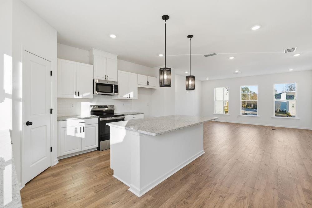 5708 Schelton Place Southeast Mableton, GA 30126 - Photo 8 of 48 a kitchen with stainless steel appliances kitchen island a refrigerator a stove a sink and a oven