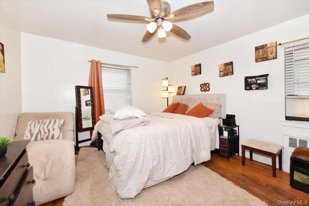 75-40 Springfield Boulevard, Unit 1 Queens, NY 11364 - Photo 11 of 18 a bedroom with a bed and a chandelier