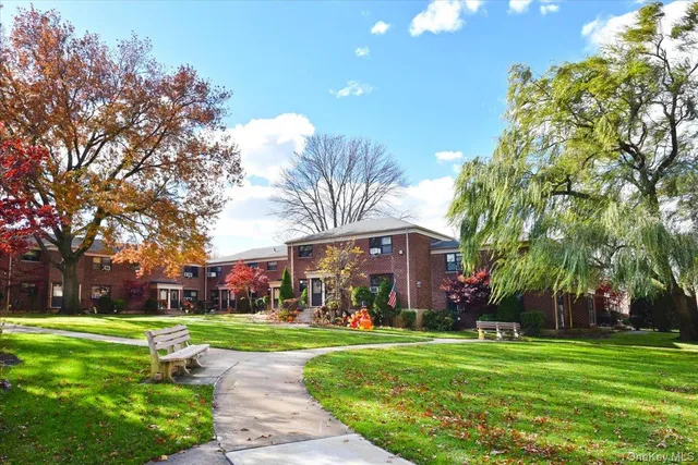 a front view of a house with garden and trees
