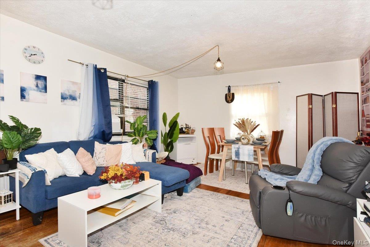 75-40 Springfield Boulevard, Unit 1 Queens, NY 11364 - Photo 5 of 18 a living room with furniture and a large window