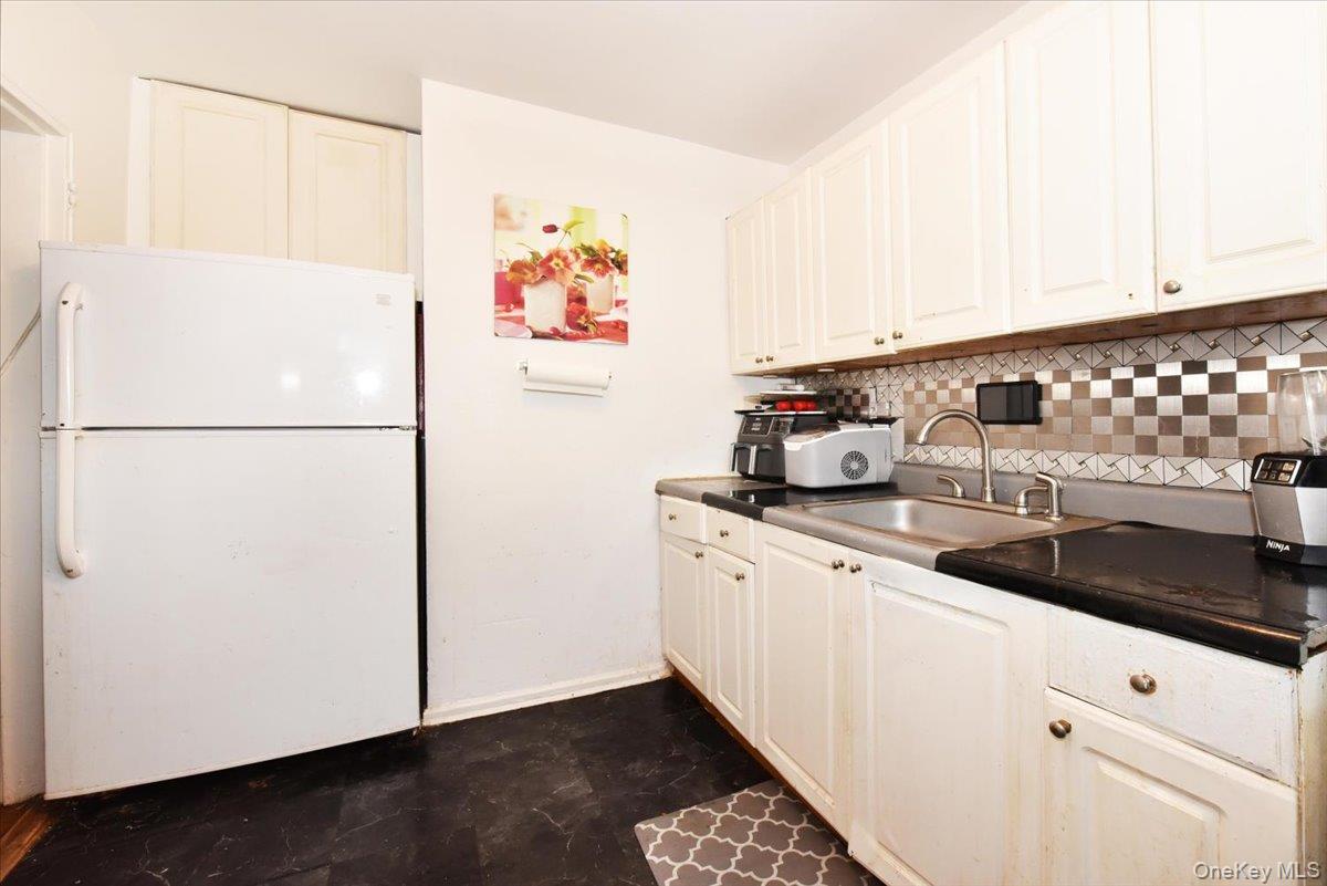 75-40 Springfield Boulevard, Unit 1 Queens, NY 11364 - Photo 8 of 18 a kitchen with refrigerator and cabinets