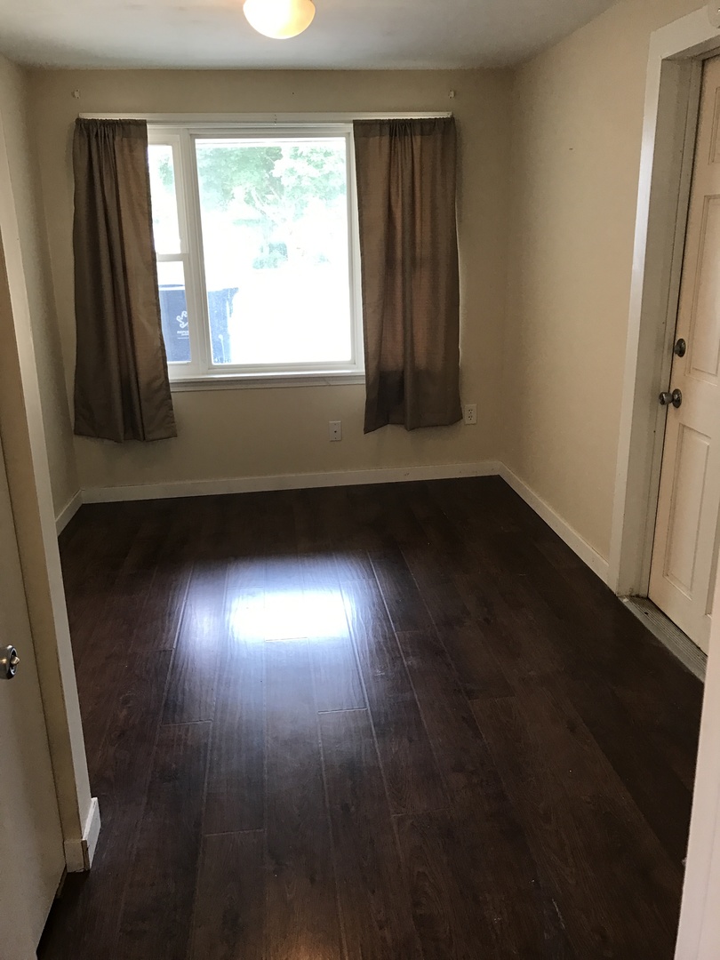 819 Price Street Morris, IL 60450 - Photo 5 of 10 an empty room with wooden floor and windows