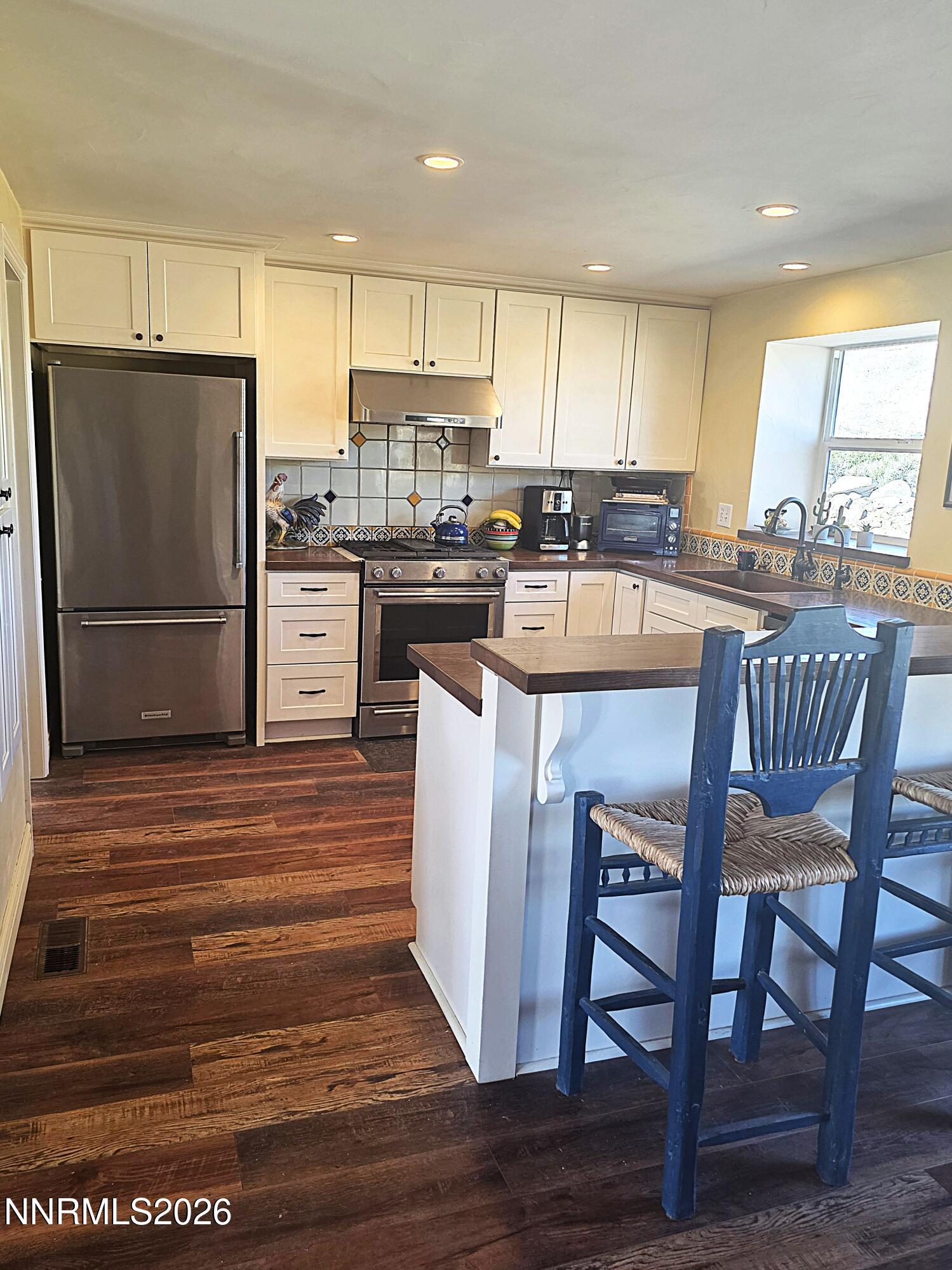 110 Quarterhorse Circle Reno, NV 89508 - Photo 10 of 32 a kitchen with stainless steel appliances granite countertop a refrigerator a stove a kitchen island with a dining table and chairs